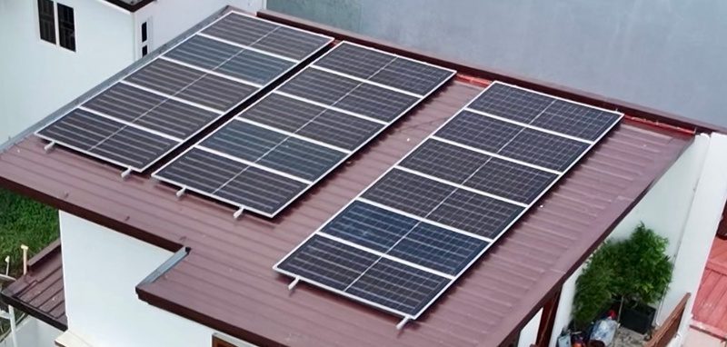 Three rows of panels on a maroon metal roof, seen from above.