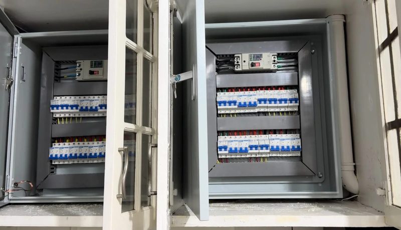 Two open breaker enclosures side by side, the breakers in neat rows with the wiring dressed behind.